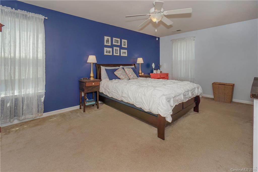 7550 West Berkeley Road, Unit 22 Denver, NC 28037 - Photo 9 of 20 a spacious bedroom with a bed and a chandelier