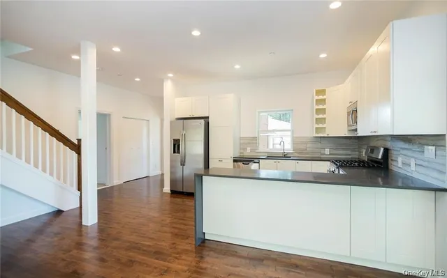 a hallway with white cabinets and wooden floor