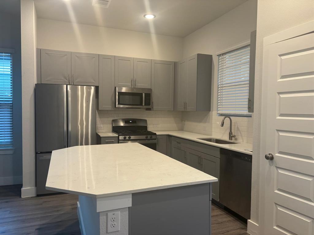 825 West Mayfield Road, Unit 224 Arlington, TX 76015 - Photo 7 of 25 a kitchen with a sink a kitchen island and stainless steel appliances