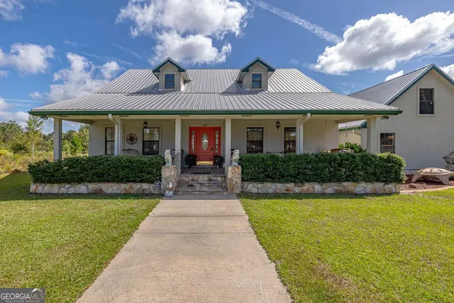 a front view of a house with yard and green space