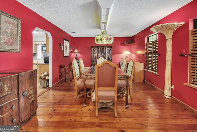 a kitchen with stainless steel appliances granite countertop a refrigerator a sink dishwasher a stove and white countertops with wooden floor