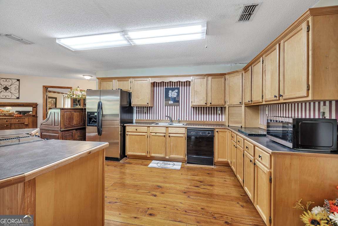 220 Chickasaw Road Hoboken, GA 31542 - Photo 34 of 55 a kitchen with stainless steel appliances a stove top oven a sink a refrigerator white cabinets and wooden floor