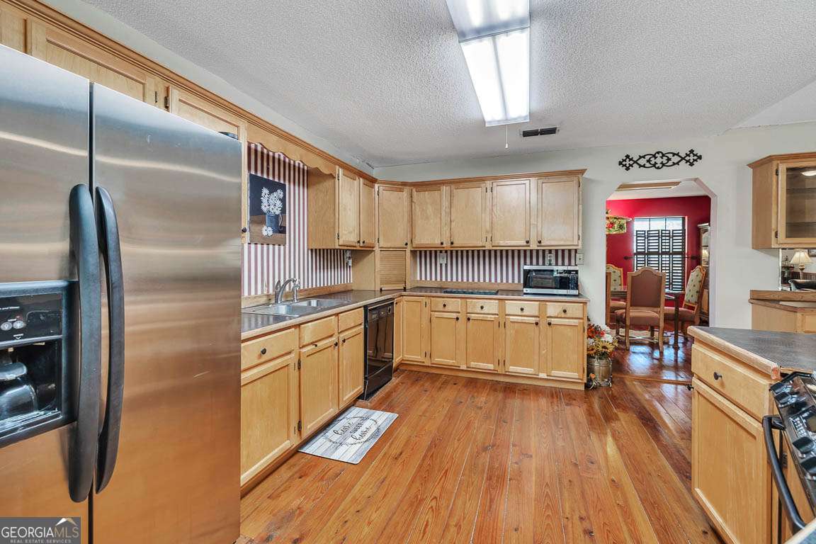 220 Chickasaw Road Hoboken, GA 31542 - Photo 35 of 55 a kitchen with stainless steel appliances granite countertop a refrigerator a sink dishwasher a stove and white countertops with wooden floor