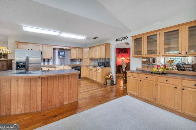 a living room with furniture kitchen view and a window