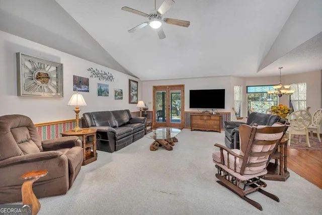 a living room with furniture kitchen view and a wooden floor