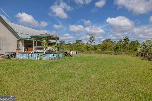 a view of a big yard with a house in the background