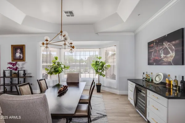 a dining room with furniture potted plants and wooden floor