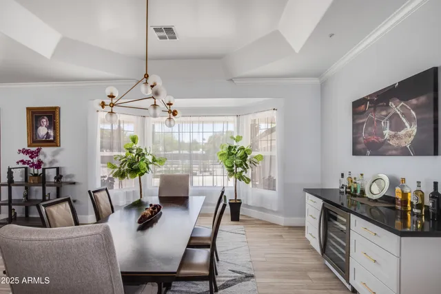 a dining room with furniture potted plants and wooden floor