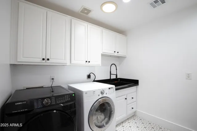 a utility room with sink dryer and washer