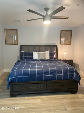 a bedroom with a bed a painting on the wall and a chandelier