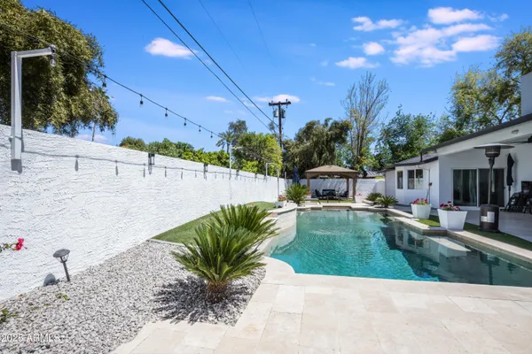 a view of a house with backyard and sitting area