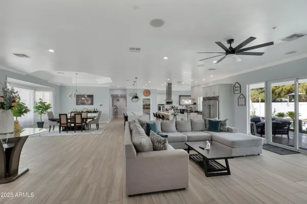 a living room with furniture and a dining table with wooden floor