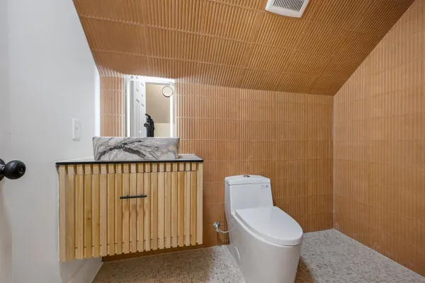 a bathroom with a granite countertop toilet and a sink