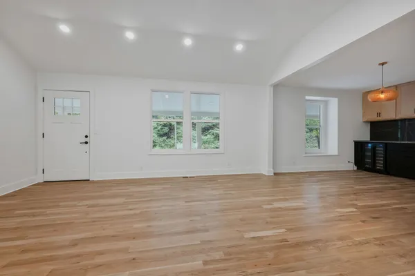 an empty room with window and wooden floor