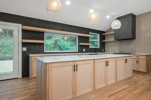 a kitchen with granite countertop a sink cabinets and wooden floor