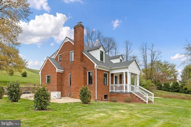 a front view of house with yard and trees in the background