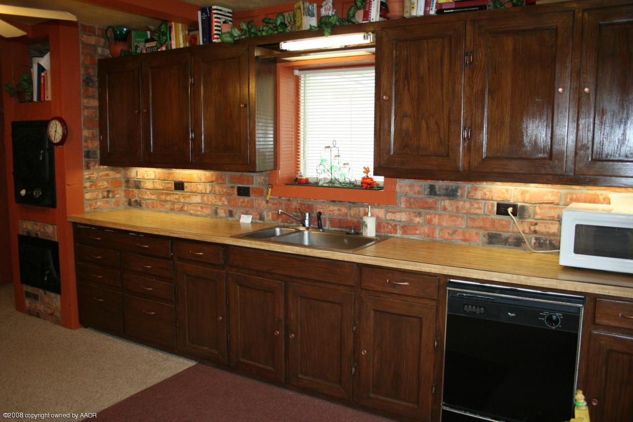4104 Bowie Street Amarillo, TX 79110 - Photo 5 of 18 a kitchen with granite countertop wooden cabinets a sink and dishwasher