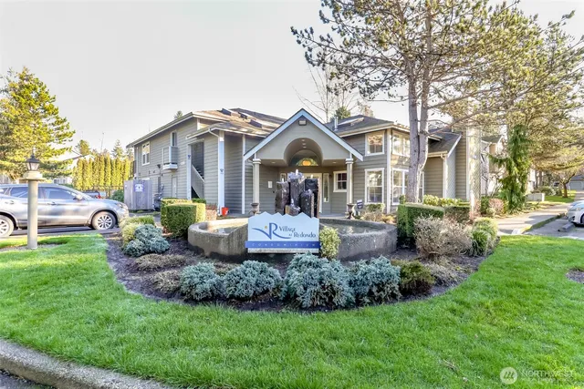 a front view of a house with a garden and trees