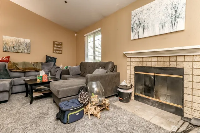 a living room with furniture a fireplace and a window