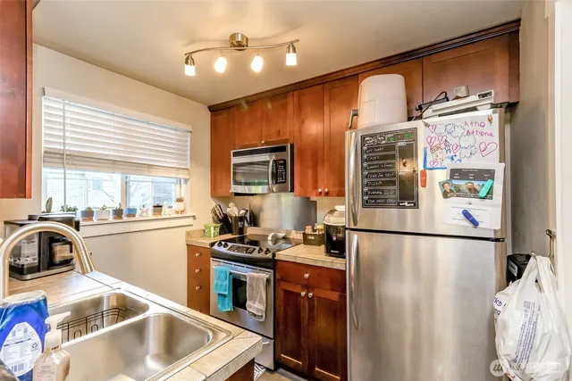 a kitchen with stainless steel appliances wooden cabinets and a stove top oven
