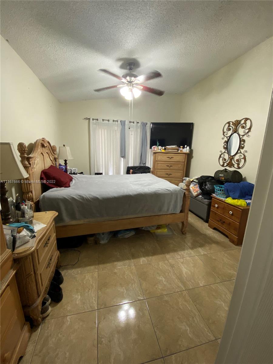 2879 West 75th Terrace Hialeah, FL 33018 - Photo 11 of 16 a bedroom with a bed and ceiling fan