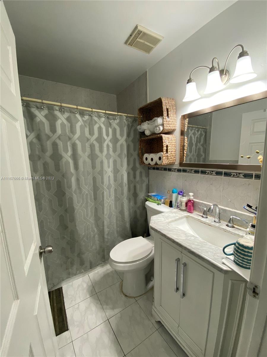 2879 West 75th Terrace Hialeah, FL 33018 - Photo 13 of 16 a bathroom with a sink toilet mirror and vanity