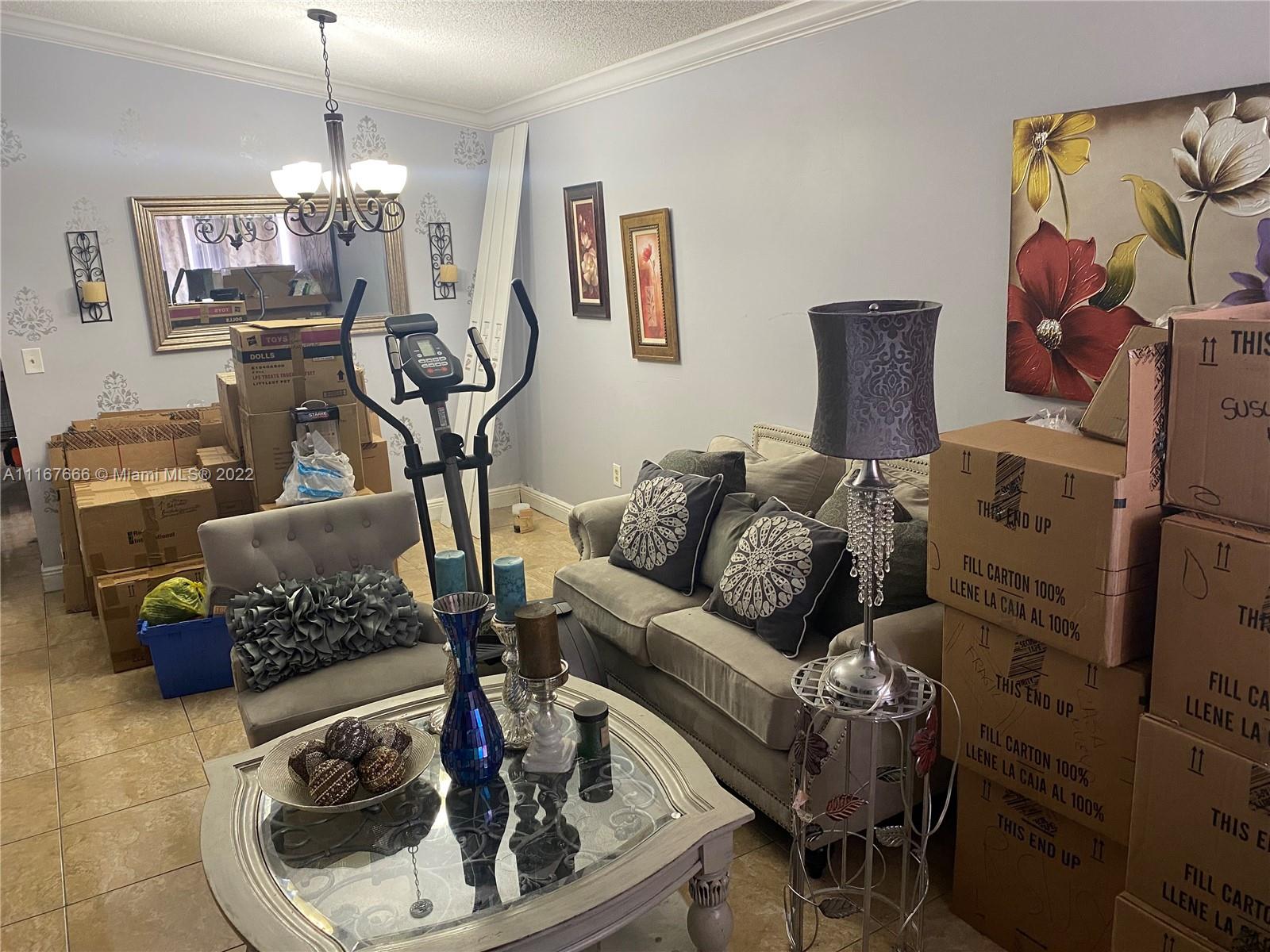 2879 West 75th Terrace Hialeah, FL 33018 - Photo 2 of 16 a living room with furniture and a chandelier