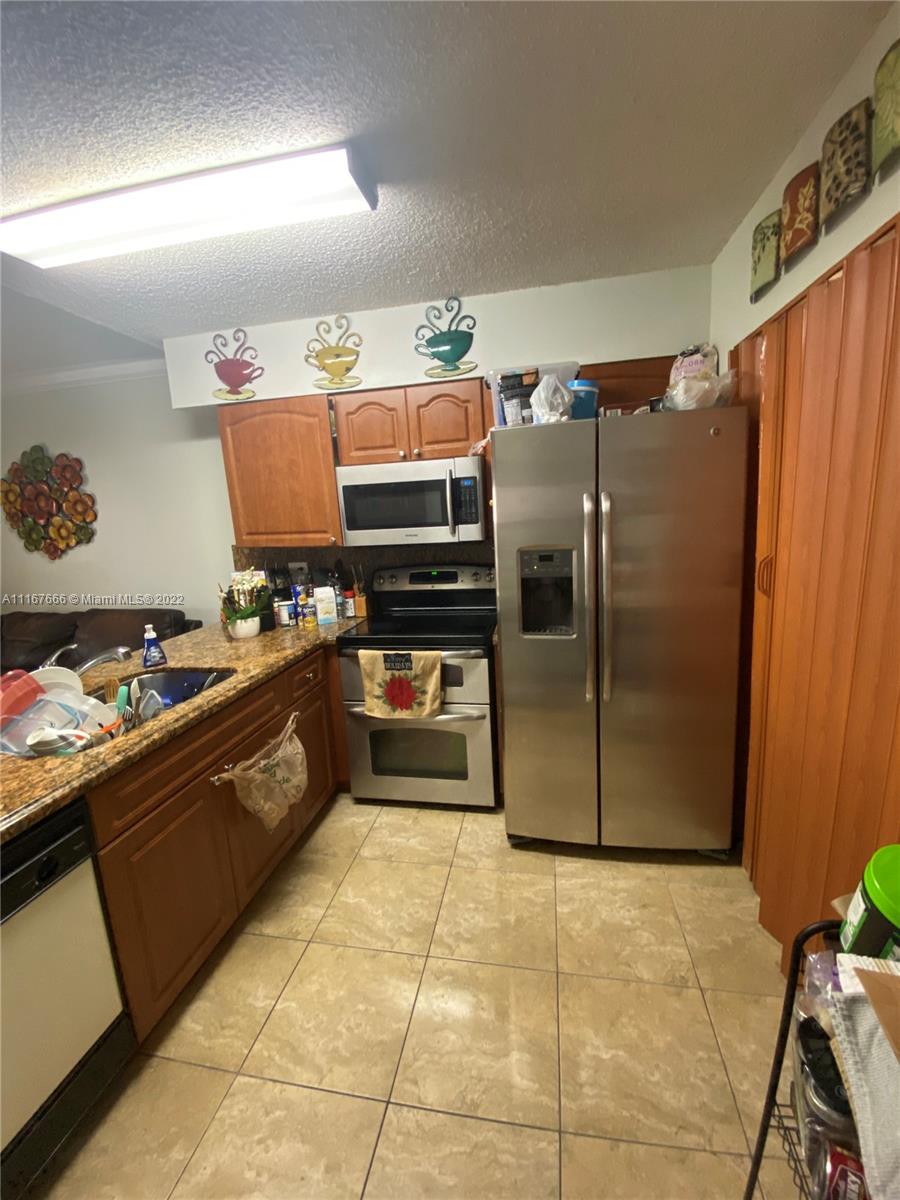 2879 West 75th Terrace Hialeah, FL 33018 - Photo 3 of 16 a kitchen with stainless steel appliances granite countertop a refrigerator and a stove