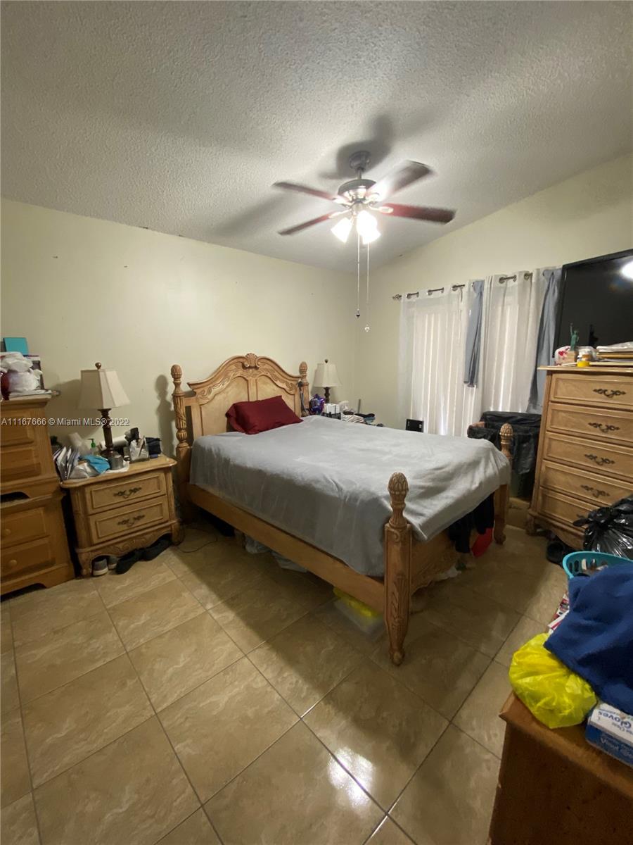 2879 West 75th Terrace Hialeah, FL 33018 - Photo 10 of 16 a bedroom with a bed and a chandelier