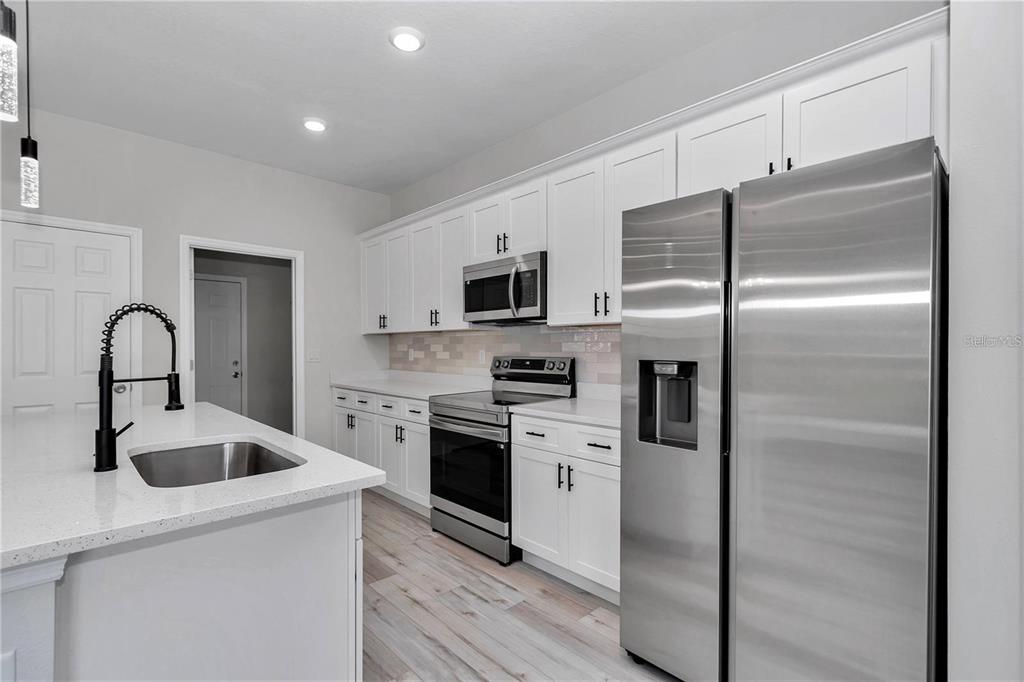 3875 Southwest 169th Ln Road Ocala, FL 34473 - Photo 17 of 46 a kitchen with a refrigerator sink and stainless steel appliances
