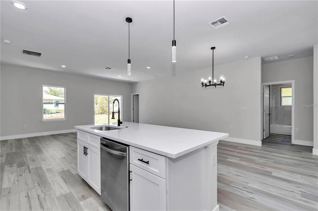 3875 Southwest 169th Ln Road Ocala, FL 34473 - Photo 20 of 46 a view of a kitchen island a sink wooden floor and a chandelier