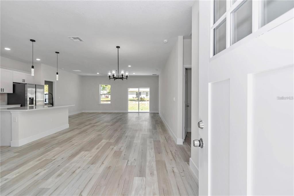 3875 Southwest 169th Ln Road Ocala, FL 34473 - Photo 22 of 46 a view of a hallway with wooden floor and a kitchen