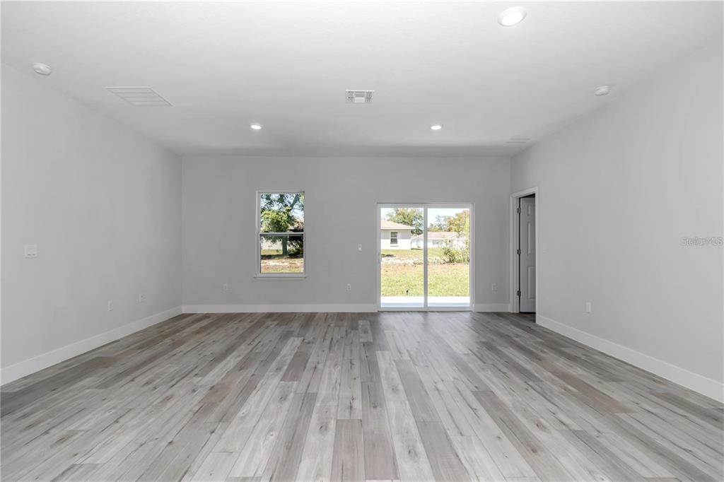 3875 Southwest 169th Ln Road Ocala, FL 34473 - Photo 27 of 46 an empty room with wooden floor and windows