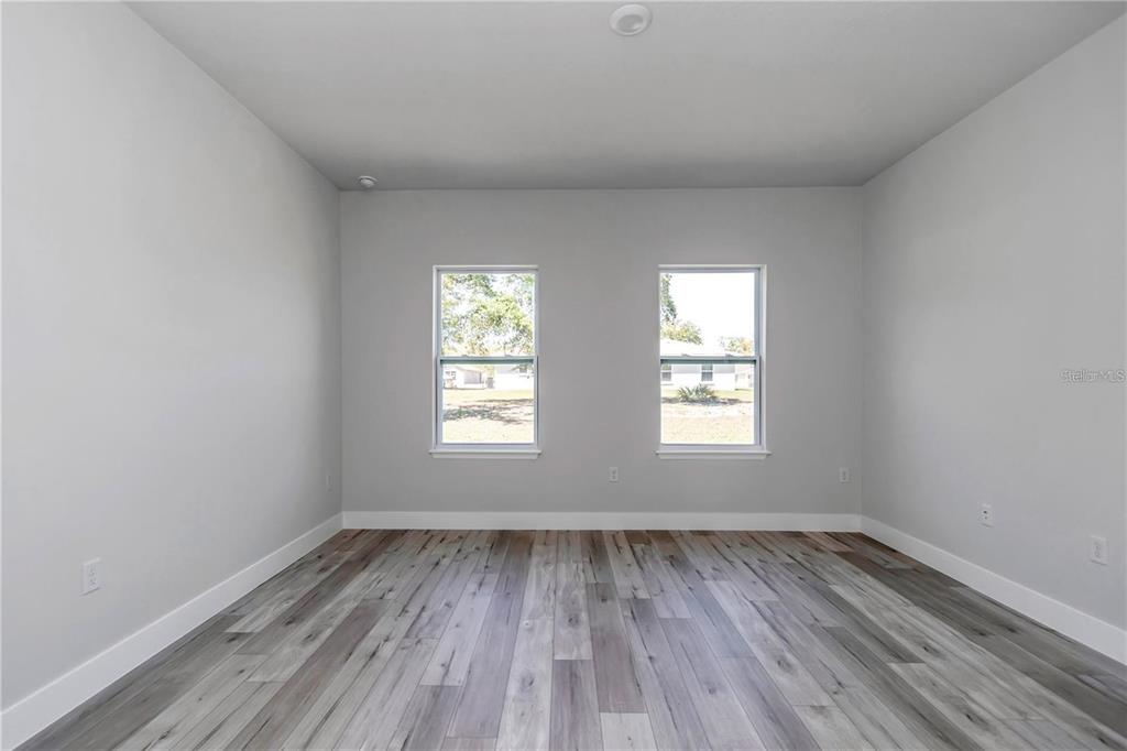 3875 Southwest 169th Ln Road Ocala, FL 34473 - Photo 28 of 46 an empty room with wooden floor and windows