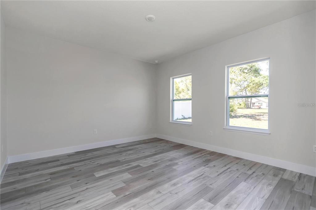 3875 Southwest 169th Ln Road Ocala, FL 34473 - Photo 29 of 46 a view of an empty room with wooden floor and a window