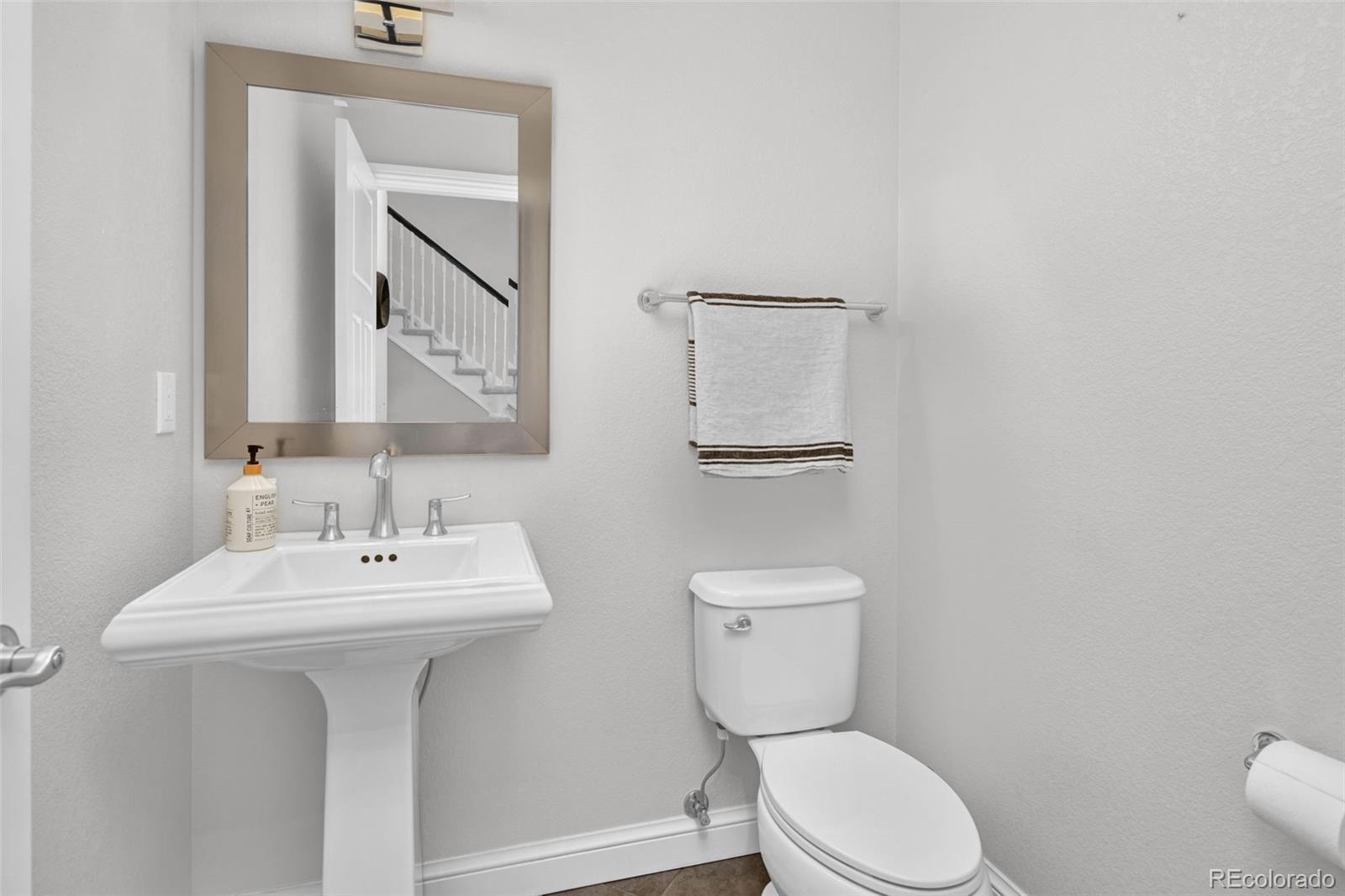 9575 3rd Place Denver, CO 80230 - Photo 14 of 38 a bathroom with a toilet sink and mirror