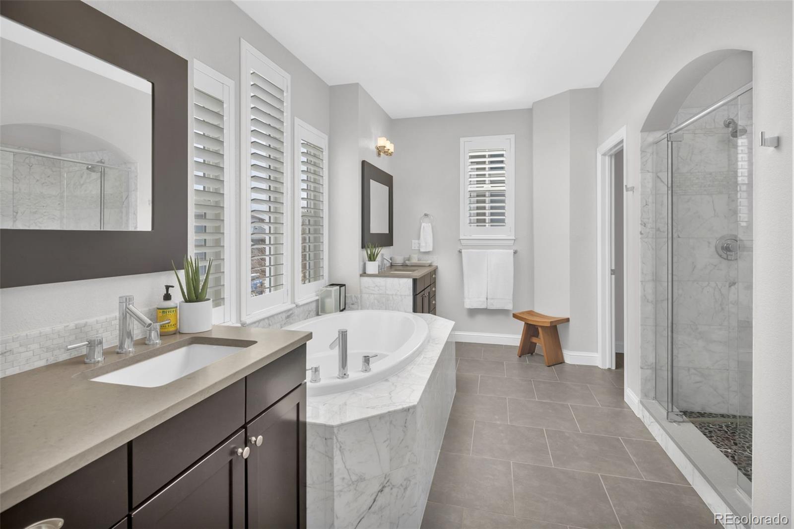 9575 3rd Place Denver, CO 80230 - Photo 21 of 38 a spacious bathroom with a double vanity sink a mirror and a bathtub