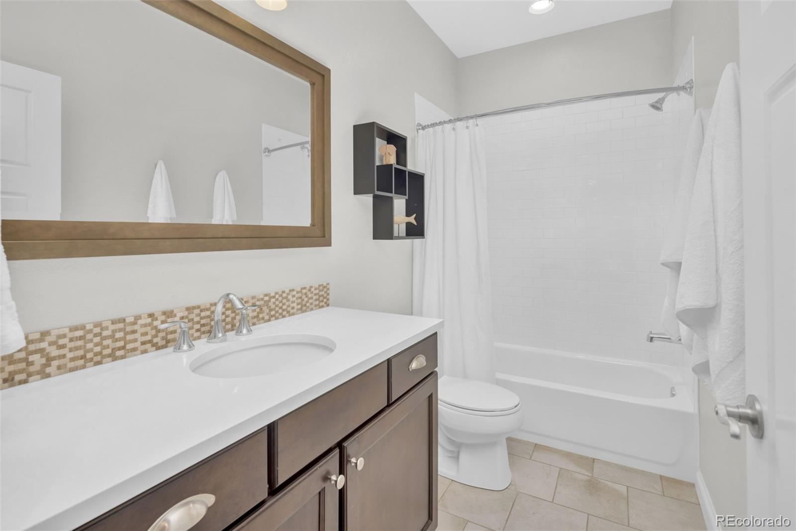 9575 3rd Place Denver, CO 80230 - Photo 29 of 38 a bathroom with a sink a toilet and shower