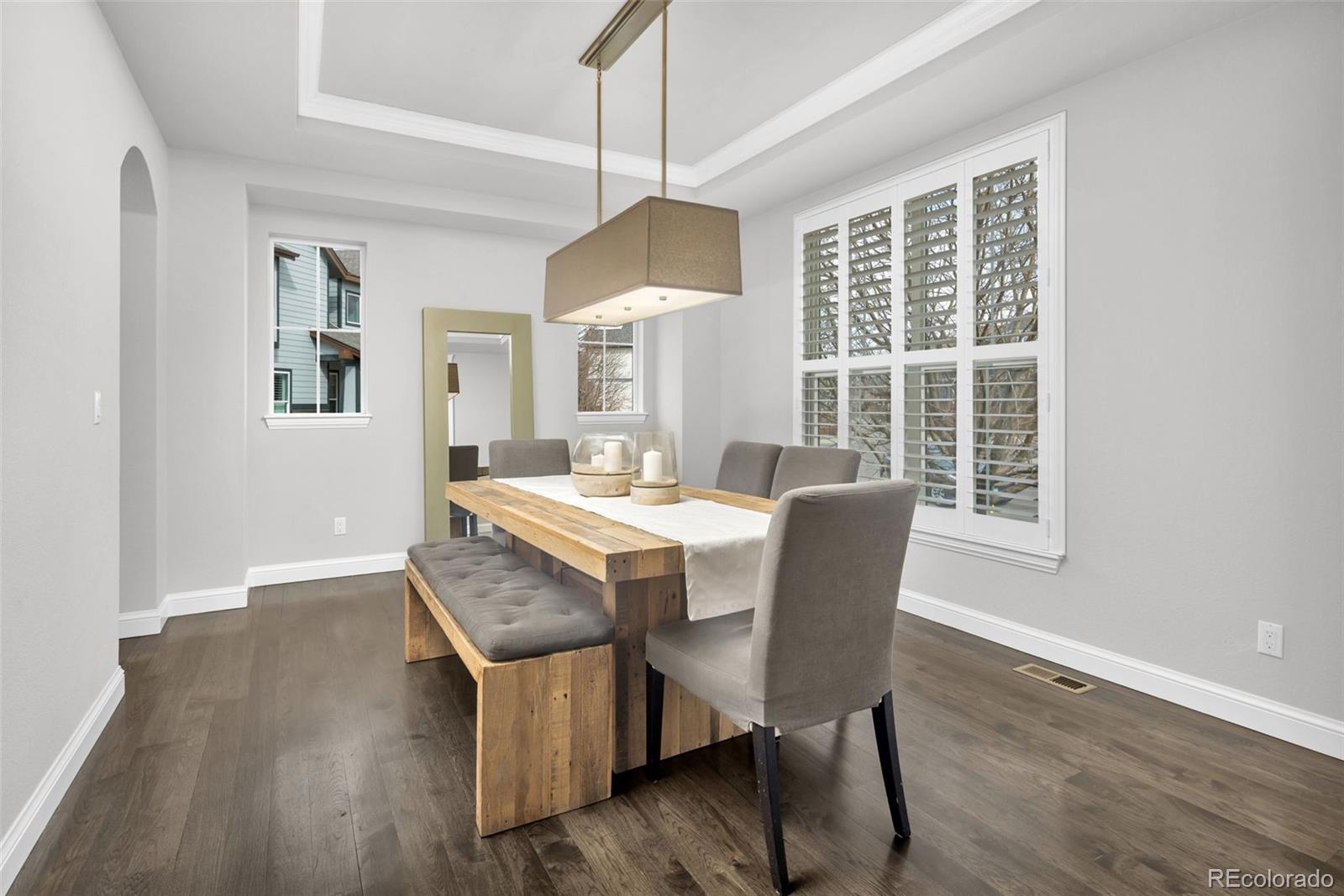9575 3rd Place Denver, CO 80230 - Photo 10 of 38 a dining room with wooden floor a chandelier a wooden table and chairs