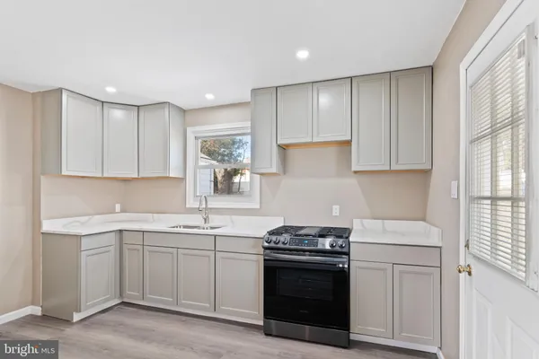 a kitchen with a sink stove and cabinets