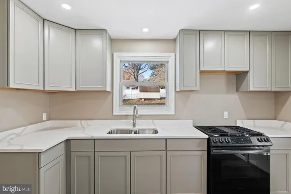 a kitchen with a sink stove and cabinets
