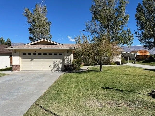 a front view of a house with a garden and trees