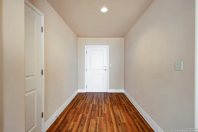 a view of a hallway with wooden floor