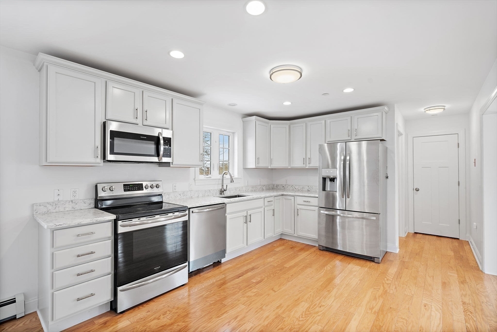 16 Hodgkins Road, Unit 2 Rockport, MA 01966 - Photo 3 of 19 a kitchen with granite countertop appliances cabinets and a wooden floor