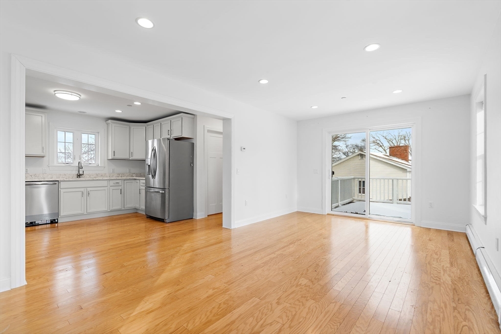 16 Hodgkins Road, Unit 2 Rockport, MA 01966 - Photo 7 of 19 a view of an empty room with wooden floor and a kitchen