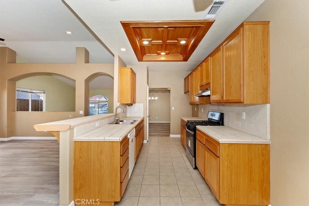 12278 Shadow Drive Victorville, CA 92392 - Photo 11 of 32 a large kitchen with stainless steel appliances granite countertop a sink and cabinets