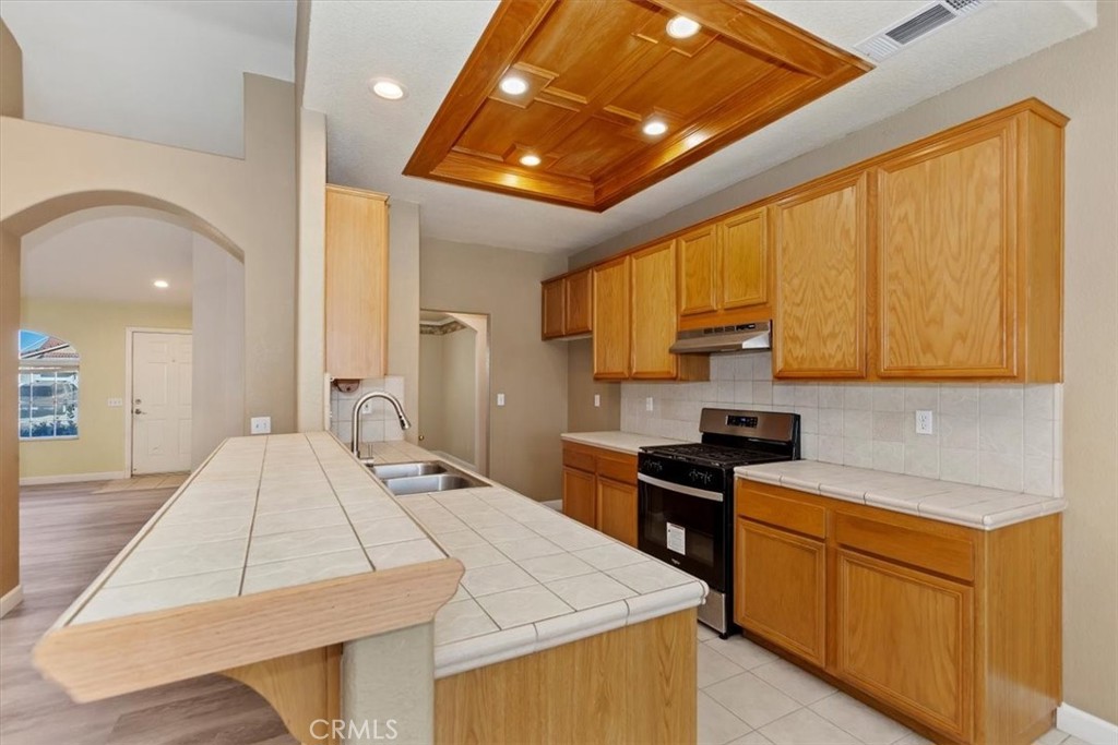 12278 Shadow Drive Victorville, CA 92392 - Photo 12 of 32 a kitchen with a sink a stove and cabinets