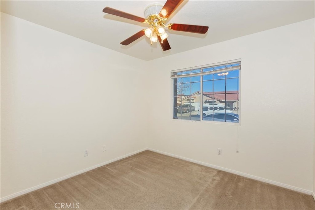 12278 Shadow Drive Victorville, CA 92392 - Photo 15 of 32 an empty room with a window and a ceiling fan