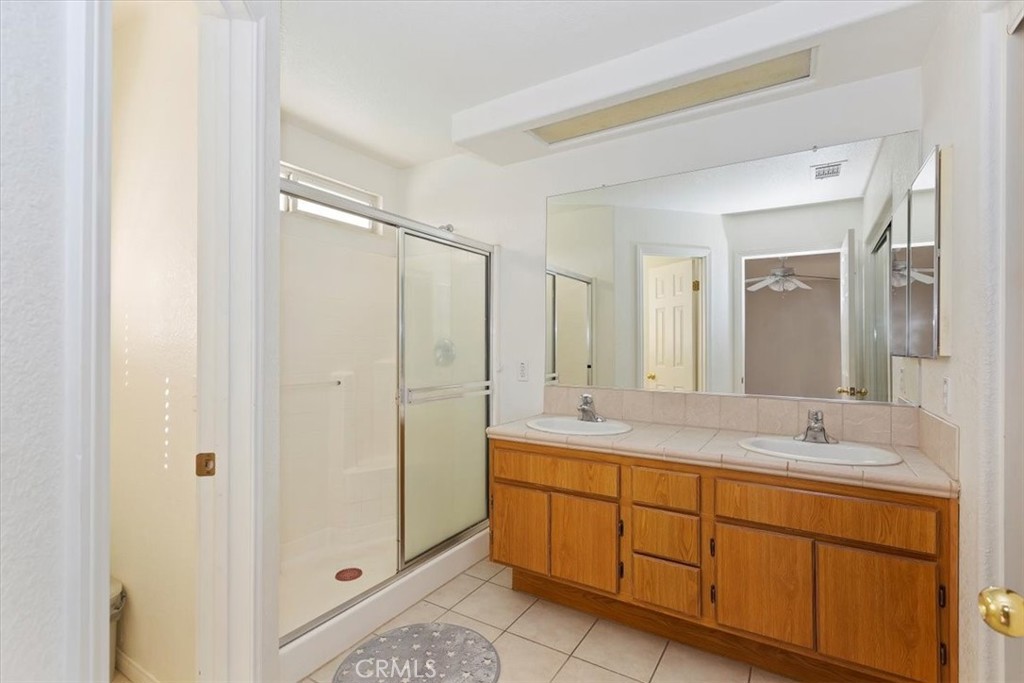 12278 Shadow Drive Victorville, CA 92392 - Photo 23 of 32 a bathroom with a shower sink and mirror