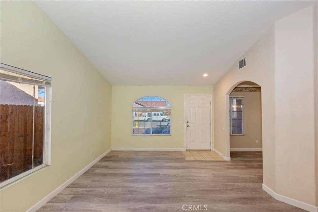 12278 Shadow Drive Victorville, CA 92392 - Photo 4 of 32 a view of an empty room with window and wooden floor